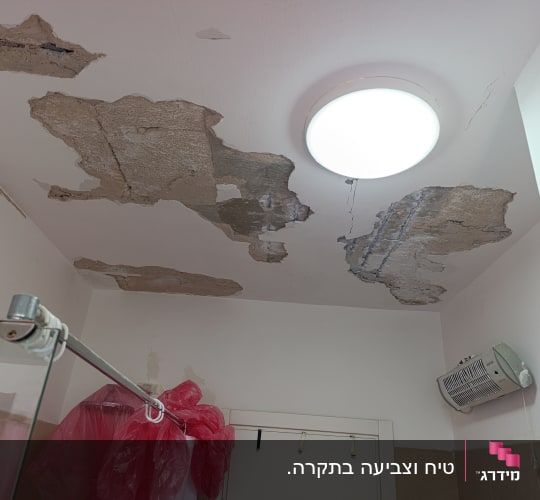 תקרה עם קילופי צבע ונזקי רטיבות בחדר אמבטיה